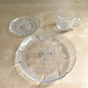 Pu&ograve; includere: Un set di tre piatti in vetro trasparente con un design floreale. I piatti sono in vetro trasparente e hanno una superficie testurizzata. I piatti sono perfetti per servire spuntini, dessert o antipasti.