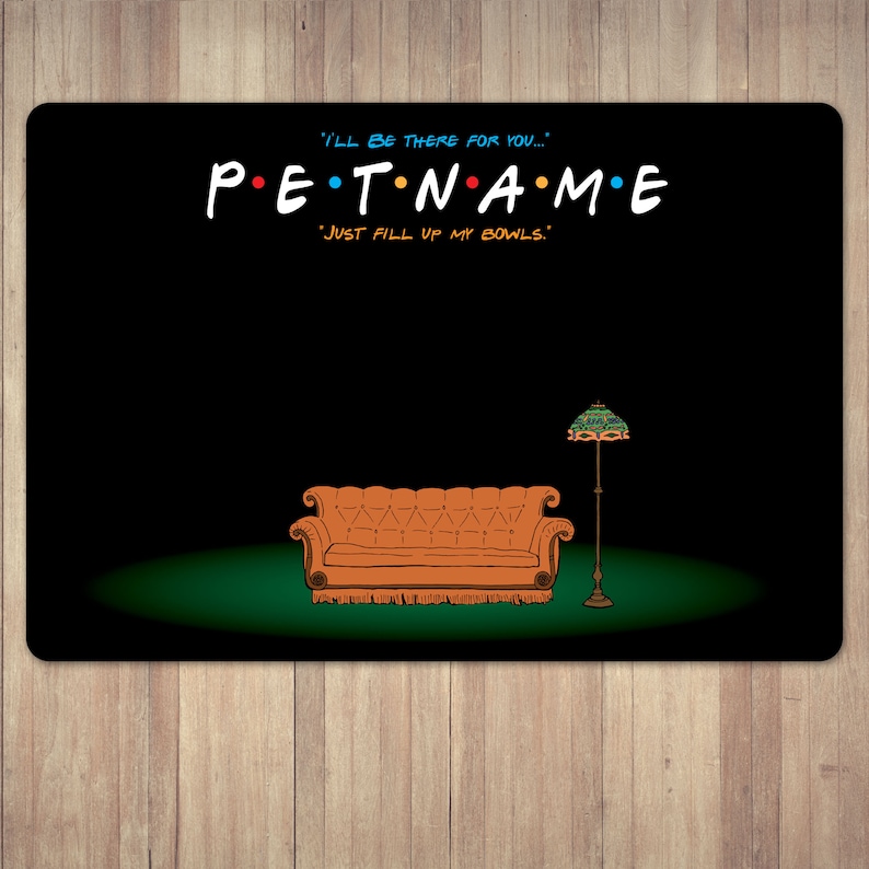 以下が含まれることがあります： 人気テレビ番組にインスパイアされた、カラフルな文字で「PET NAME」と書かれた黒いペット用プレースマット。デザインには、漫画のオレンジ色のソファ、ランプ、「I'll be there for you...」と「Just fill up my bowls.」というフレーズが含まれています。