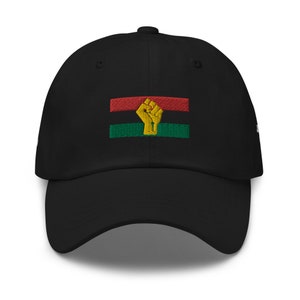 May include: Black baseball cap with an embroidered red, green, and yellow flag with a raised fist in the center.
