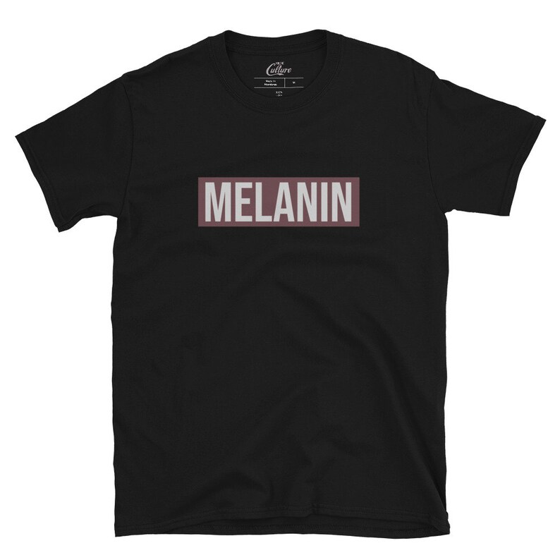 May include: Black t-shirt with a brown rectangle that says "MELANIN" in white letters.