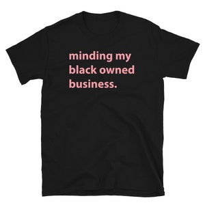 May include: Black t-shirt with the text "minding my black owned business." printed in pink.