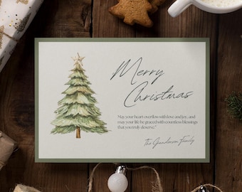 May include: A Christmas-themed flat lay featuring a greeting card with a watercolor Christmas tree and the words "Merry Christmas." The scene includes wrapped gifts, a gingerbread cookie, a cup of coffee, and decorative elements.