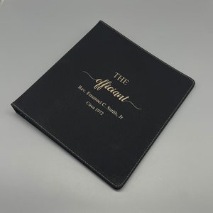 May include: Black leather binder with gold embossed text that reads "THE officiant Rev. Emmanuel C. Smith, Jr. Circa 1972"