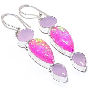 May include: Dangle earrings with pink and lavender gemstones in a silver setting. The earrings feature a large, pear-shaped pink opal, with smaller lavender stones above and below. The gemstones are set in silver.