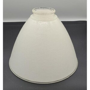 May include: A conical glass lamp shade with a frosted, textured white finish. The shade features a smooth, circular opening at the top for mounting and a wider, open base with a clear glass rim edge, providing a simple and functional design.