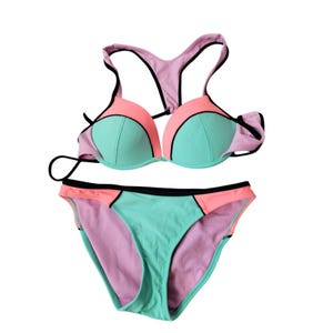 Op de afbeelding: Een tweedelige bikini met een color-block ontwerp in mintgroen, koraalroze en lichtlavendel. De top heeft voorgevormde cups met een racerback-stijl, terwijl het bikinibroekje een bijpassend color-block patroon heeft met zwarte biezen.