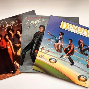 May include: A set of three ceramic mugs with a speckled, matte finish. The mugs are in shades of cream, light gray, and dark gray. Each mug has a simple, minimalist design, perfect for coffee or tea.