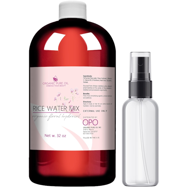 K&ouml;nnte beinhalten: Eine gro&szlig;e bernsteinfarbene Kunststoffflasche mit Rice Water Mix organic floral hydrosol und wei&szlig;em Verschluss, beschriftet mit Inhaltsstoffen und 946 ml Nettoinhalt, neben einer kleineren, durchsichtigen Spr&uuml;hflasche mit schwarzer Pumpe.