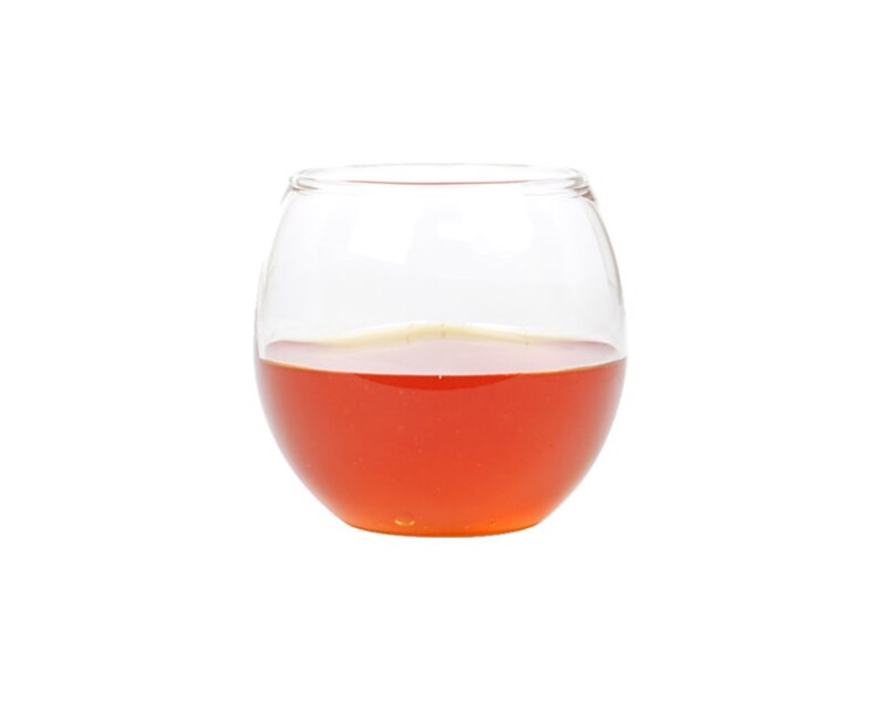 May include: A clear glass bowl filled with a bright orange liquid, likely honey.