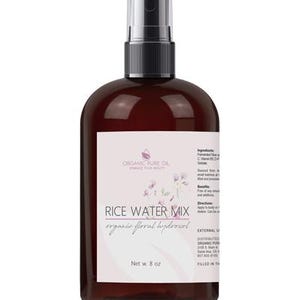 K&ouml;nnte beinhalten: Eine 8 oz braune Kunststoff-Spr&uuml;hflasche mit Rice Water Mix organic floral hydrosol. Das wei&szlig;e Etikett zeigt das Organic Pure Oil Logo, florale Illustrationen und gedruckten Text mit Angaben zu Inhaltsstoffen, Vorteilen und Anwendung.