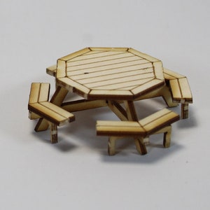 May include: Three wooden picnic tables of different sizes. The largest table has a hexagonal top and six benches. The middle table has a hexagonal top and six benches. The smallest table has a hexagonal top and six benches.
