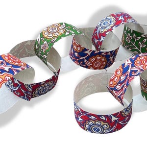 May include: Paper chain links with floral patterns in red, blue, orange, and green. The links are connected, creating a decorative chain. The design features a repeating flower motif on a white background.