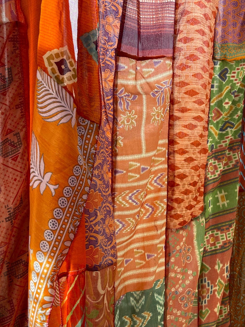 Pode incluir: Um remendo de retalhos de tecido costurados juntos para criar um tecido colorido e texturizado. O tecido &eacute; uma mistura de laranja, vermelho, verde e azul com v&aacute;rios padr&otilde;es.