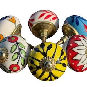Peut inclure: Un ensemble de six boutons de placard ronds en céramique arborant divers motifs floraux et botaniques peints à la main dans des couleurs vives comme le rouge, le jaune, le bleu et le vert, avec une base et une vis en métal doré.