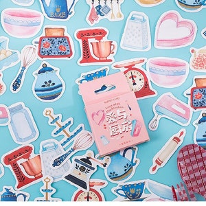 May include: A set of colorful kitchen-themed stickers featuring various kitchen appliances, utensils, and food items. The stickers are on a blue background and include a memo card that says "Love with the kitchen".