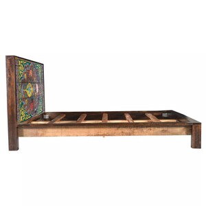 Puede incluir: Un marco de cama de madera con una cabecera de patrones coloridos. La cabecera est&aacute; hecha de madera recuperada y presenta un dise&ntilde;o geom&eacute;trico. El marco de la cama est&aacute; hecho de madera maciza y tiene un acabado natural.