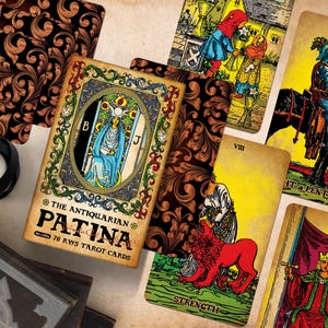 Op de afbeelding: Een set van 78 Antiquarian Patina tarotkaarten met gedetailleerde illustraties in vintage-stijl. De doos toont de titel en een centrale figuur in blauwe gewaden. Verschillende kaarten liggen uitgewaaierd en tonen kleurrijke afbeeldingen, waaronder een ridder te paard, een leeuw en een gekroonde figuur, naast donkere, gedessineerde achterkanten.