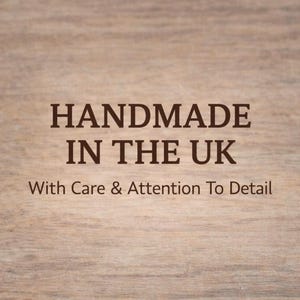 Puede incluir: Un fondo de veta de madera marr&oacute;n claro con texto en marr&oacute;n oscuro que dice HANDMADE IN THE UK seguido del texto With Care & Attention To Detail. Las letras est&aacute;n centradas y utilizan una tipograf&iacute;a serif clara, negrita y legible.