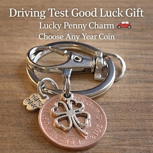 May include: A silver keychain with a copper penny charm featuring a four-leaf clover and the text "Driving Test Good Luck Gift." The penny is dated 2012. A small silver charm reads "hand made."