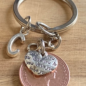 Llavero con dije de regalo de cumpleaños personalizado con forma de centavo de la suerte en bolsa de regalo para ella. Elija su año de nacimiento y su letra inicial en el cuadro desplegable