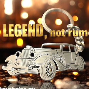 May include: A silver-colored metal keychain featuring a vintage car design. The keychain has a circular ring and a detailed car silhouette. The text "Be LEGEND, not rumor!" is displayed above the car.