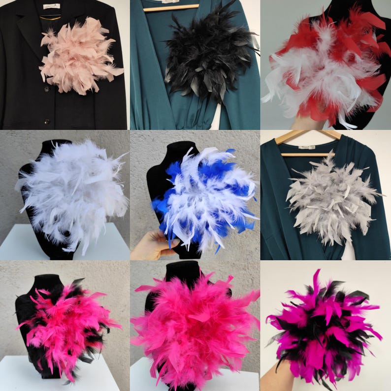May include: A collection of feather brooches in various colors, including pink, black, white, red, blue, and gray. The brooches are displayed on a black blazer and dress forms. Each brooch is made of soft, fluffy feathers.