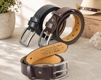 May include: Three leather belts with silver-toned metal buckles. One belt is black, and two are dark brown. The interior of the front brown belt features engraved text: CONGRATS ON BEING MY HUSBAND YOU LUCKY COWBOY! Think Of Me Whenever You Take Off Your Pants I Love You Elizabeth.