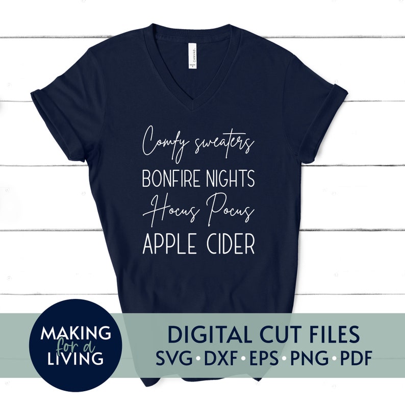 Puede incluir: Una camiseta azul marino de cuello en V con el texto "Comfy sweaters, Bonfire nights, Hocus Pocus, Apple Cider" en letras blancas.