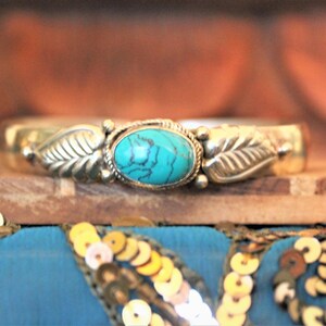 K&ouml;nnte beinhalten: Silberarmband mit einem T&uuml;rkis-Stein und Blatt-Akzenten.