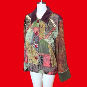 May include: A long-sleeve jacket featuring a patchwork design of various fabrics in shades of green, brown, and red. The garment includes a dark brown velvet collar, a front button closure with four red buttons, and intricate embroidery details.
