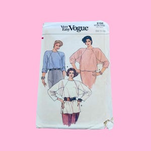 May include: A Very Easy Vogue sewing pattern envelope 9194 for sizes 14-16-18. The front features illustrations of three tops with raglan sleeves, including a light blue top with grey trousers, a peach top, and a white top with a dark belt.