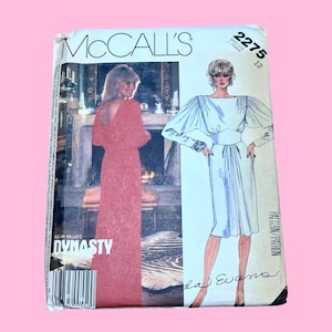 May include: A vintage McCall's sewing pattern featuring a red dress and a white dress with the text "DYNASTY". The pattern number is 2275, size 12. The cover has a pink background.