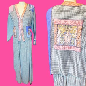 May include: A two-piece outfit consisting of a long-sleeved button-down jacket and a matching skirt, both featuring a black and white micro-check pattern. The jacket includes a large rectangular patch on the back depicting a stylized human face.