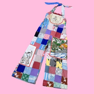 May include: A patchwork jumpsuit with a halter top and wide legs. The fabric is a mix of colorful floral and geometric patterns, including a blue and white floral pattern, a red and white checkered pattern, and a green and white polka dot pattern.