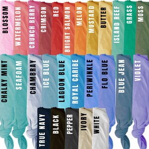 May include: A collection of 24 fabric swatches in various colors, including Chalky Mint, Blossom, Seafoam, Watermelon, Chambray, Crunch Berry, True Navy, Ice Blue, Crimson, Black, Red, Lagoon Blue, Pepper, Bright Salmon, Royal Caribe, Melon, Ivory, Periwinkle, Mustard, White, Flo Blue, Butter, Island Reef, Blue Jean, Grass, and Violet. The swatches are arranged in two rows, with the names of each color printed below.