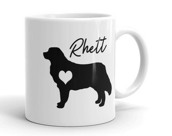 May include: White ceramic mug with a black silhouette of a Bernese Mountain Dog with a heart in its chest. The name "Rhett" is written in black cursive above the dog.