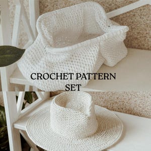 May include: A white crochet basket and a wide-brimmed crochet hat are displayed on a white shelf. The basket has a rectangular shape with a folded-over top. The hat has a rounded crown and a wide brim. The text "CROCHET PATTERN SET" is visible.