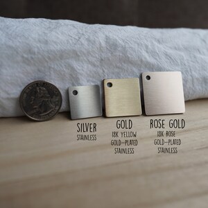 May include: Three square metal samples in silver, gold, and rose gold. The samples are labeled with their respective metal types and descriptions: "Silver Stainless", "Gold 18K Yellow Gold-Plated Stainless", and "Rose Gold 18K Rose Gold-Plated Stainless".