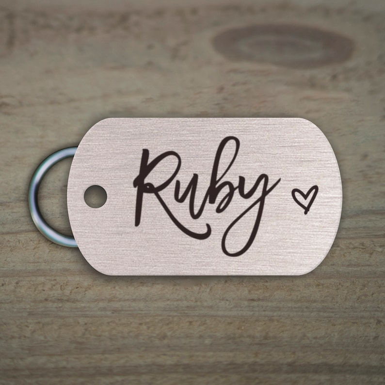 May include: Silver dog tag with a black engraved name "Ruby" and a small heart symbol.