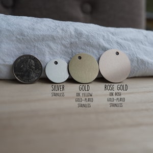 Pode incluir: Tr&ecirc;s discos met&aacute;licos redondos em prata, ouro e ouro rosa. Os discos s&atilde;o etiquetados como "Prata A&ccedil;o Inoxid&aacute;vel", "Ouro Ouro Amarelo 18K Banhado a Ouro A&ccedil;o Inoxid&aacute;vel" e "Ouro Rosa Ouro Rosa 18K Banhado a Ouro A&ccedil;o Inoxid&aacute;vel".