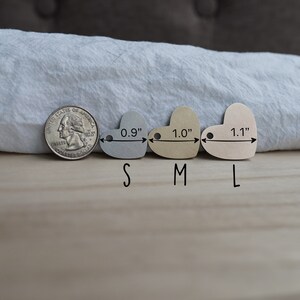 May include: Three heart-shaped metal tags in different sizes: 0.9 inches, 1.0 inches, and 1.1 inches. The tags are silver, gold, and rose gold.