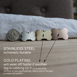 May include: Four dog tags in the shape of a bone. The tags are made of stainless steel and are shown in four different finishes: silver, gold, rose gold, and copper. The text below the tags reads "Stainless Steel extremely durable" and "Gold Plating will wear off faster if another tag is rubbing on it (to extend the lifetime of your gold plating, add a coat of lacquer or clear nail polish)"