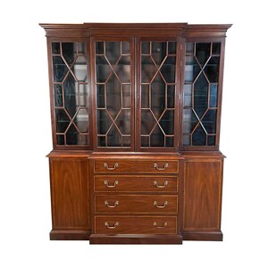 May include: A large, dark wood cabinet with glass-paned doors and drawers. The upper section features multiple glass doors with geometric patterns. The lower section has four drawers with brass handles. The cabinet is a rich, dark brown color.
