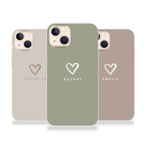 Op de afbeelding: Drie smartphonehoesjes in lichtbeige, saliegroen en taupe. Elk hoesje heeft een witte, met de hand getekende hartomtrek boven een naam in witte hoofdletters: Veronica, Rachel en Amelia. De hoesjes hebben een uitsparing voor de dubbele camera.