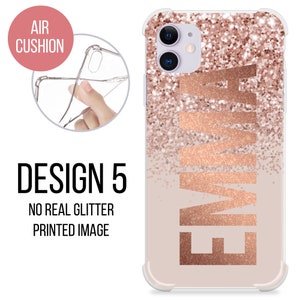 May include: A clear phone case with a rose gold glitter design and the name "EMMA" printed in a rose gold font. The case has a raised edge for protection and is compatible with most smartphones.