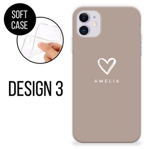 May include: A taupe phone case with a white heart design and the name "AMELIA" printed below it. The case is shown on a phone with a clear, flexible soft case. The words "SOFT CASE" and "DESIGN 3" are also visible.