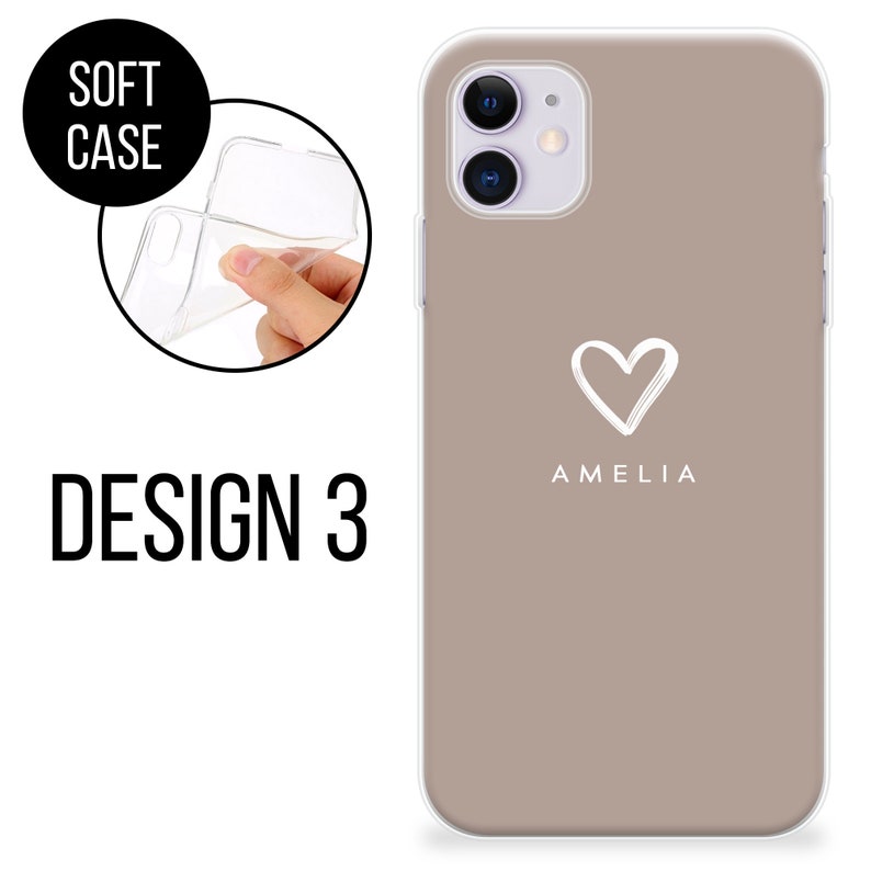 May include: A taupe phone case with a white heart design and the name "AMELIA" printed below it. The case is shown on a phone with a clear, flexible soft case. The words "SOFT CASE" and "DESIGN 3" are also visible.