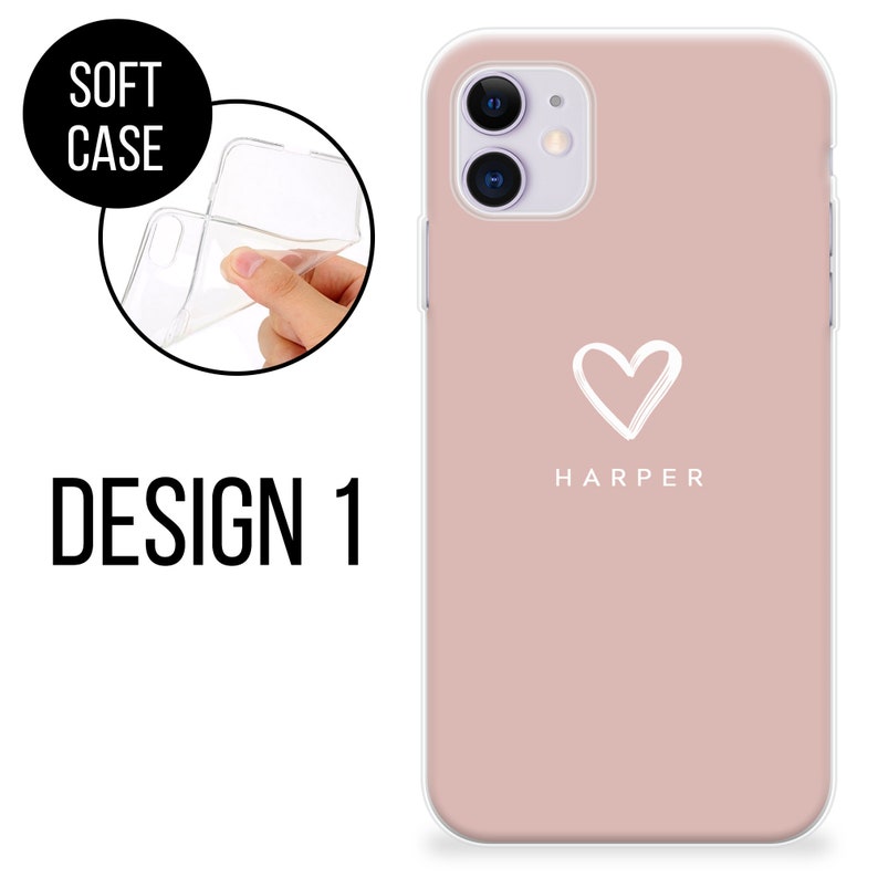 May include: A soft phone case in Design 1. The case is a dusty rose color with a white heart graphic and the name "HARPER" printed below. The image also shows a clear, flexible case being held.