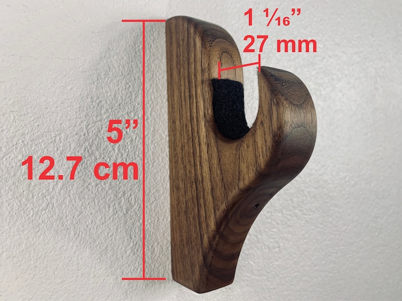 May include: A dark brown wooden wall mount hook with a 1 1/16 inch (27 mm) projection and a 5 inch (12.7 cm) height. The hook is designed to hold items like coats, hats, or bags.