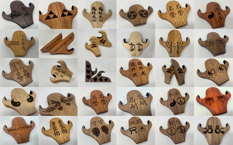 May include: A collection of 20 wooden guitar stands with various designs and engravings. The stands are made of light and dark wood and feature different patterns, symbols, and text. Some of the engravings include Japanese characters, a yin yang symbol, a peace sign, and a wolf's head.